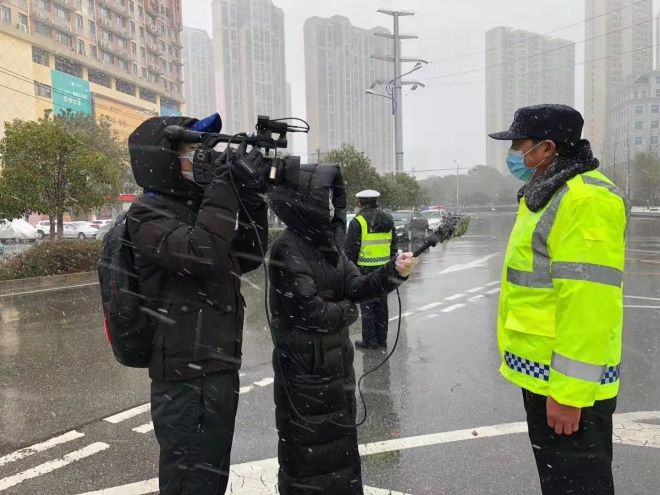 孝感市融媒體中心楊亞玲（風(fēng)雪中，采訪疫情期間重返一線的退休警察）_副本.jpg.jpg